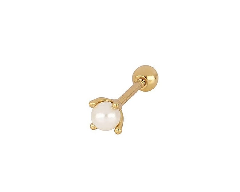 May include: A gold stud earring with a small white pearl