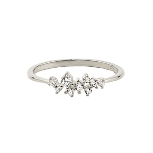 May include: A silver ring with a cluster of small, clear stones set in a delicate band.