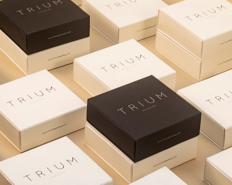 May include: Multiple square boxes with the word "TRIUM JEWELRY" printed on them. The boxes are in various shades of brown and white.