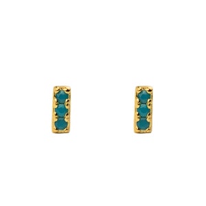 May include: A pair of gold stud earrings with a vertical bar design. Each bar is set with three turquoise gemstones.
