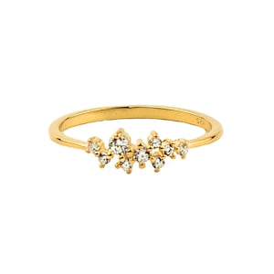 May include: A delicate gold band ring with a cluster of small, clear diamonds set in a random pattern along the top of the band.
