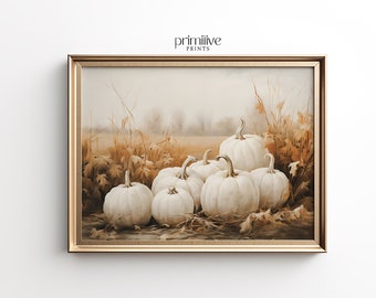 May include: A framed print featuring a still life of white pumpkins. The pumpkins are clustered together in a field of dried grasses and leaves, with a soft, neutral background. The frame is gold, and the print is labeled "PRIMITIVE PRINTS".