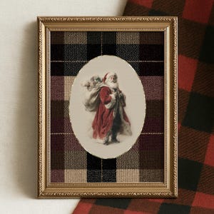 May include: A framed print featuring Santa Claus carrying a sack of toys. The image is set within an oval frame, surrounded by a gold-colored frame. The background is a plaid pattern in shades of black, brown, and burgundy.