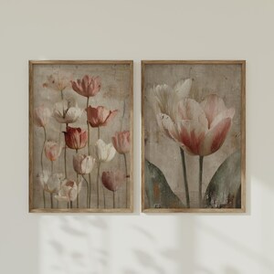 May include: Two framed art prints featuring vintage-style tulip illustrations. The tulips are in shades of pink, red, and white against a textured, neutral background. The frames are a light brown color.