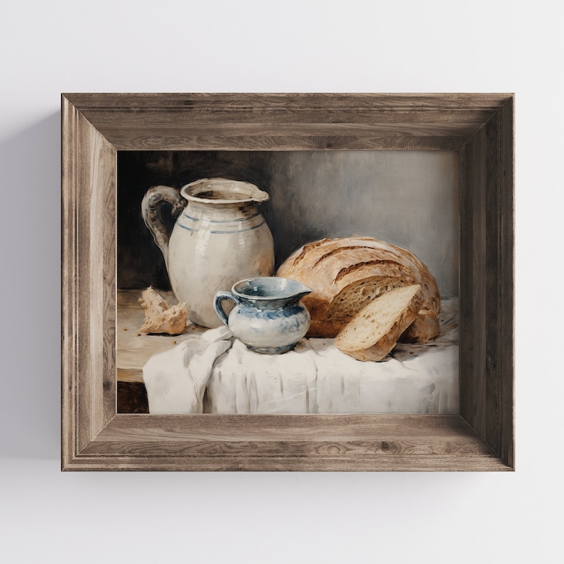 Peut inclure: Peinture encadr&eacute;e repr&eacute;sentant une nature morte avec un pain, une petite cruche bleue et blanche, et une grande cruche blanche &agrave; rayures bleues. Un morceau de pain est cass&eacute;. La peinture est de style rustique.