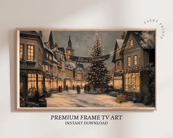 May include: A framed print of a winter village scene at night. The artwork depicts a snow-covered street lined with buildings, illuminated by warm light from windows and street lamps. A banner reads "Merry Christmas" above a decorated Christmas tree.