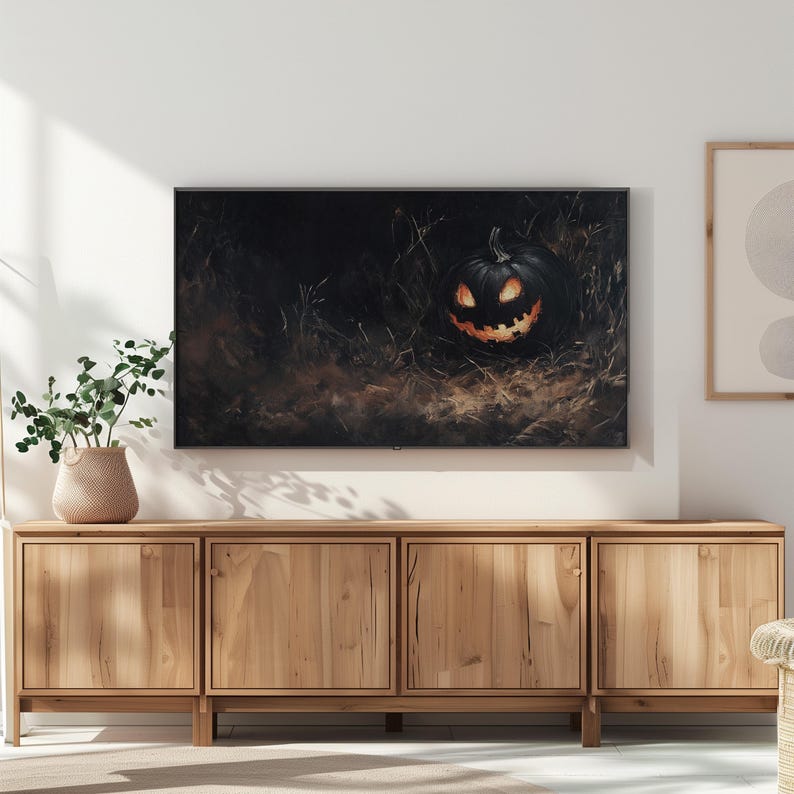 May include: A wooden entertainment center with three drawers and three doors. The center is in a living room with a television displaying a dark image of a jack-o-lantern.