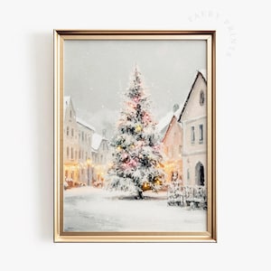 May include: A framed winter scene painting depicts a snow-covered town square with a decorated Christmas tree. The tree is illuminated with colorful lights, and the buildings are dusted with snow. The artwork is in a gold frame.