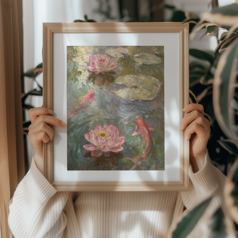Puede incluir: Pintura enmarcada que representa una serena escena de estanque. Lirios de agua rosas y peces koi nadan entre nen&uacute;fares en un estilo impresionista. La obra de arte est&aacute; encerrada en un marco de madera de color claro, a&ntilde;adiendo un toque de elegancia.