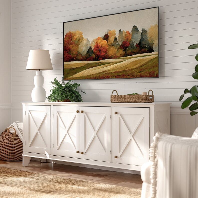 May include: White cabinet with four doors and brass knobs. The cabinet has a wood grain finish and a decorative X-shaped design on each door. A painting of a landscape with trees and rolling hills hangs above the cabinet.