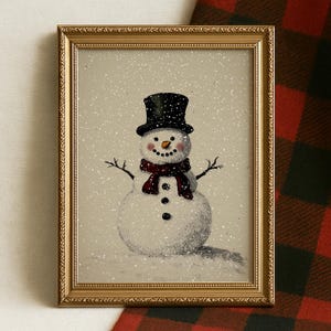 May include: Framed artwork depicting a snowman. The snowman is wearing a black top hat and a red scarf, with a carrot nose and coal eyes and buttons. The artwork is set against a snowy background and framed in a gold-coloured frame.