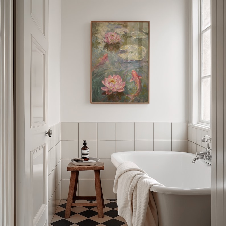 Puede incluir: Una pintura enmarcada de una escena de estanque con nen&uacute;fares rosas y peces koi cuelga sobre una ba&ntilde;era blanca. El ba&ntilde;o tiene azulejos blancos, un taburete de madera y un suelo a cuadros blanco y negro.