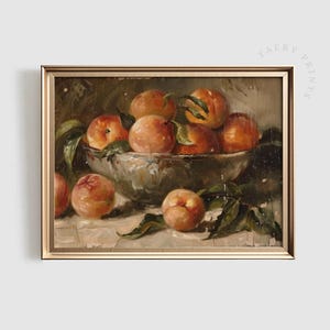Peut inclure: Peinture encadrée représentant une nature morte avec un bol rempli de pêches mûres. Les pêches, aux tons orangés et rouges, sont accompagnées de feuilles vertes. Le bol est gris, sur fond neutre.