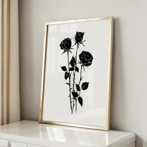May include: Black and white print of three roses in a gold frame. The roses are stylized and have a vintage feel.