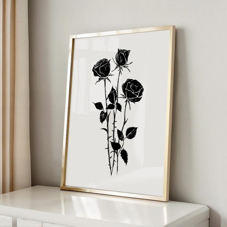 May include: Black and white print of three roses in a gold frame. The roses are stylized and have a vintage feel.
