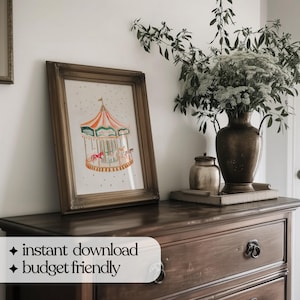 May include: A framed print of a colourful carousel with a white background and gold stars. The print is hanging on a wall above a wooden dresser with drawers.