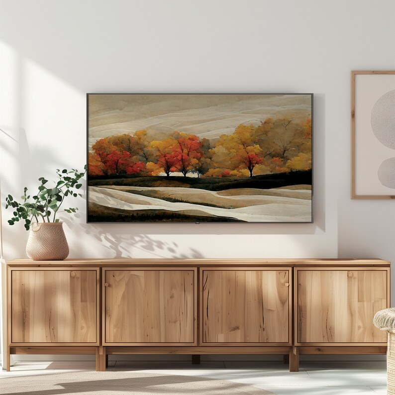 Puede incluir: Un mueble de TV de madera con cuatro puertas, que presenta una pintura de paisaje enmarcada de un campo con &aacute;rboles en tonos rojos, naranjas, amarillos y verdes. La pintura est&aacute; sobre un fondo de nubes blancas y grises.