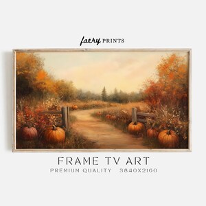 May include: A painting depicting a winding path through a field of pumpkins in autumn. The path is flanked by trees with orange, yellow, and red leaves. The sky is a soft blue with clouds. The painting is framed in a light wood frame.