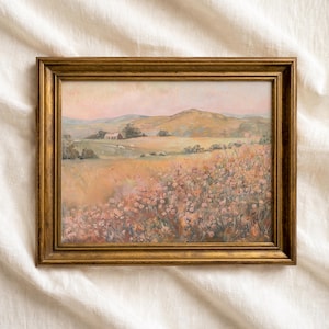 May include: A framed landscape painting in a gold-coloured frame. The artwork shows a field of flowers, a rolling hill, and a farmhouse. The colour palette includes soft pinks, yellows, and greens. The painting is in a gold-coloured frame.