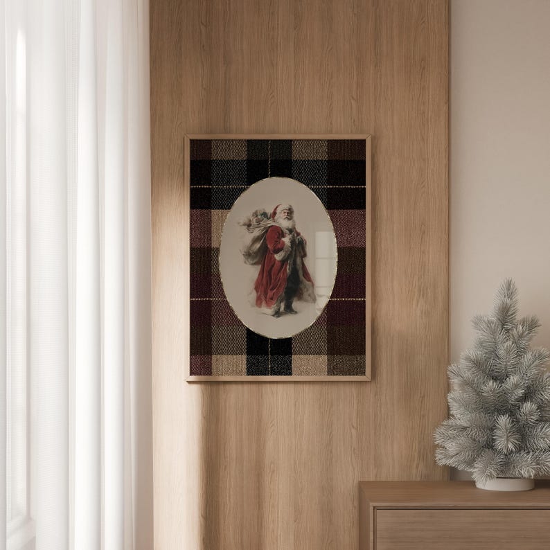 May include: A framed print featuring an oval image of Santa Claus in a red coat carrying a sack. The print is set against a plaid background of black, brown, and burgundy. The frame is a light wood color.