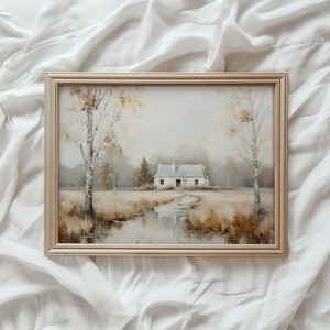 May include: A framed painting of a white cottage with a stream in front of it. The cottage is surrounded by trees and bushes. The painting is in a light wood frame.
