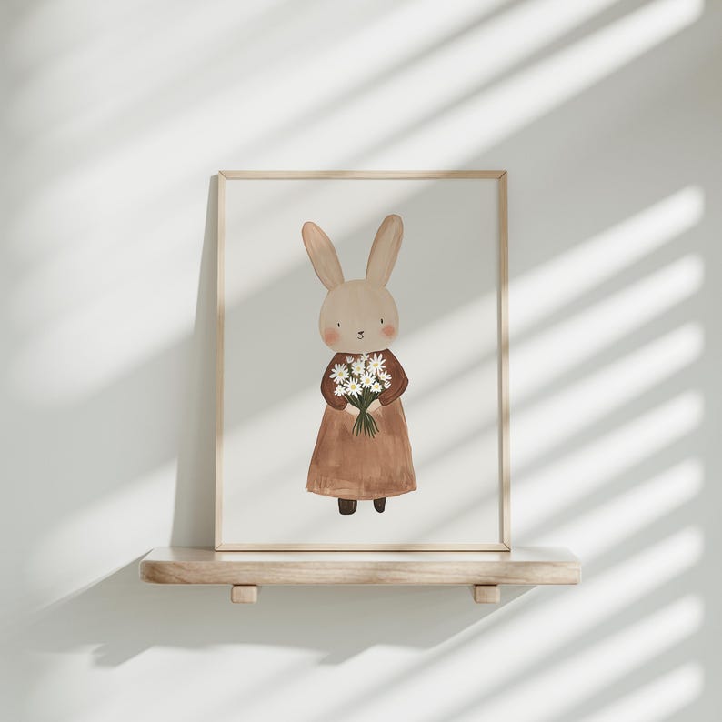 May include: A framed illustration of a brown rabbit wearing a brown dress and holding a bouquet of white flowers.