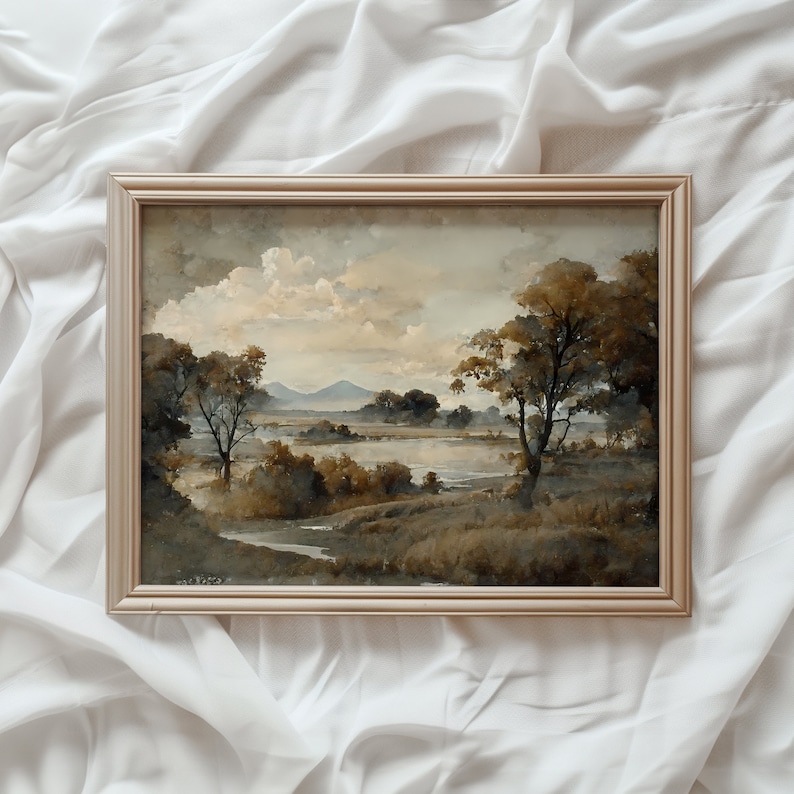 May include: A framed watercolor painting depicting a landscape scene with a lake, trees, and mountains in the distance. The painting is in shades of brown, green, and blue.