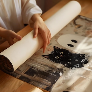 May include: A person is rolling up a white paper tube, revealing a painting of a black cat with yellow eyes. The cat is wearing a black and white patterned collar and is sitting in front of a white ghost with two black eyes.