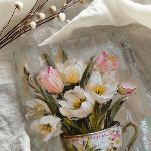 May include: A painting of a bouquet of white and pink tulips in a vintage teacup. The tulips are arranged in a vase with a floral pattern. The background is a light brown color.