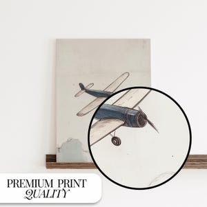 May include: A vintage-style print featuring a blue and white airplane illustration. The artwork showcases a detailed drawing of a propeller plane, with the text "PREMIUM PRINT QUALITY" at the bottom. The print has a neutral color palette.