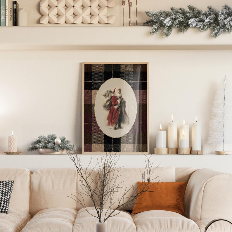 May include: A framed print featuring Santa Claus carrying a sack, set against a plaid background. The artwork is displayed above a beige sofa, complemented by candles and festive decor, creating a cozy holiday scene.