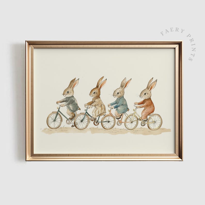 Op de afbeelding: Een ingelijste print met vier antropomorfe konijnen op fietsen. De konijnen dragen verschillende outfits. Het kunstwerk is in aquarel stijl, tegen een neutrale achtergrond en goudkleurig omlijst. Kinderlijk thema.