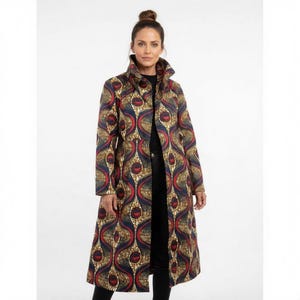 May include: A long coat with a striking pattern and a high collar. The coat displays a repeating design in red, blue, and gold. It is open at the front and worn over a black outfit. The coat reaches the ankles.