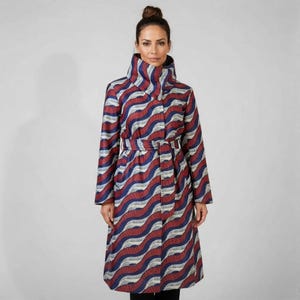 May include: A long coat featuring a high collar and a wavy design in red, navy blue, and white. The coat has long sleeves and a matching belt. The knee-length coat is made of a textured fabric, suitable for cooler weather.