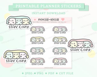 May include: Printable planner stickers featuring a cute cartoon mochi character with the text "Stay Cozy". The stickers are in pastel colors and have a rounded rectangular shape.