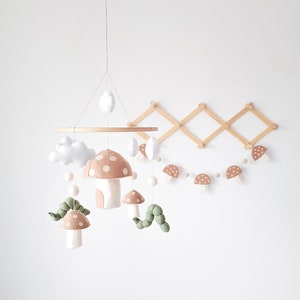 Introducing our charming handmade baby mobile, inspired by a delightful forest theme. This adorable creation features woodland creatures like a cute caterpillar nestled among vibrant mushrooms, perfectly enhancing your nursery decor.