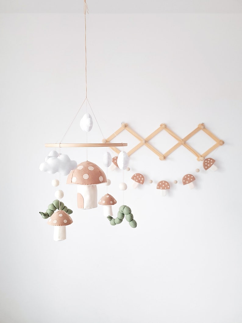 Introducing our charming handmade baby mobile, inspired by a delightful forest theme. This adorable creation features woodland creatures like a cute caterpillar nestled among vibrant mushrooms, perfectly enhancing your nursery decor.