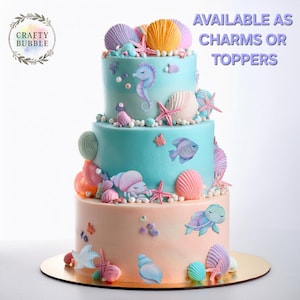 May include: A three-tiered cake decorated with a seahorse, fish, turtle, starfish, and seashells. The cake is available as charms or toppers.  AVAILABLE AS CHARMS OR TOPPERS