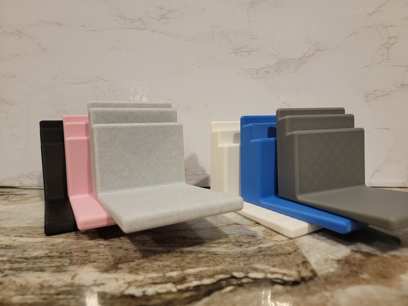 May include: Four different colored plastic organizers, each with three tiers, stacked on top of each other. The colors are black, pink, white, and blue.
