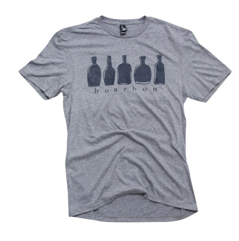 Puede incluir: Una camiseta gris jaspeada con un gr&aacute;fico de seis botellas de bourbon y la palabra "bourbon" impresa en negro.