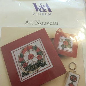May include: A cross-stitch kit featuring three designs inspired by Art Nouveau. The kit includes a card with a circular design, a smaller card with a floral design, and a keychain with a stylised tree design. The kit is packaged in a clear plastic bag with a V&A Museum label.