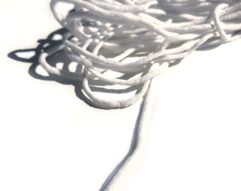May include: A close-up of a white elastic cord, commonly used for face masks or other crafts.