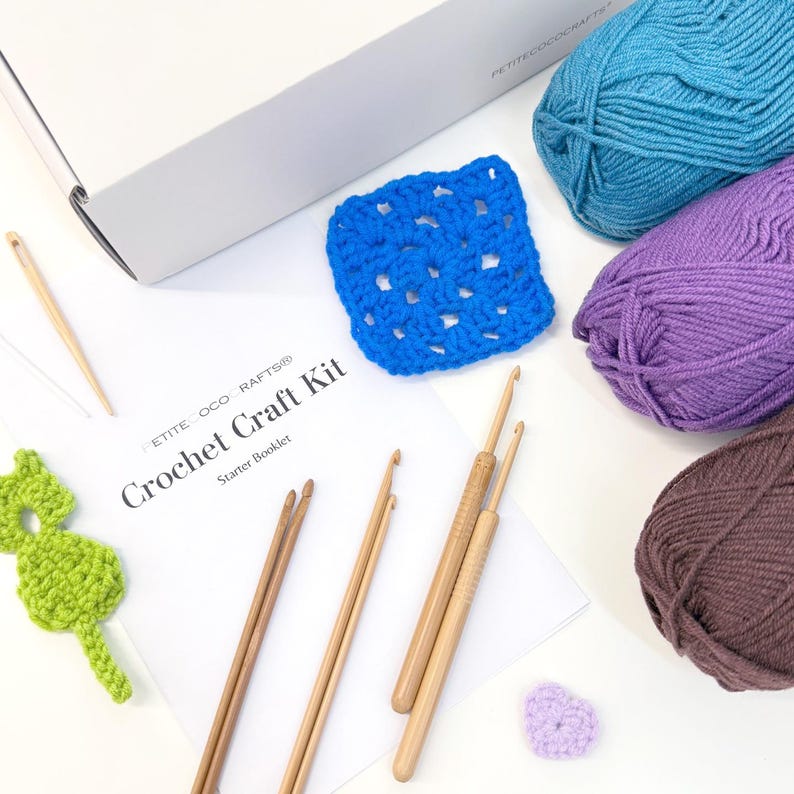 May include: A crochet craft kit with a starter booklet, crochet hooks, yarn in blue, purple, and brown, and a blue crocheted square. A green seahorse and a small purple heart are also included.