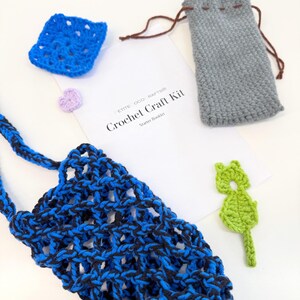May include: A crochet craft kit with a blue and black net bag, a blue square, a gray drawstring pouch, a green leaf-shaped applique, a purple heart, and a booklet that reads "Crochet Craft Kit Starter Booklet."