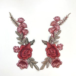 Könnte beinhalten: Zwei rote und rosafarbene gestickte Blumenapplikationen mit einer Rose und Blättern. Die Applikationen eignen sich perfekt, um Kleidung, Taschen oder Heimtextilien einen Hauch von Eleganz zu verleihen.