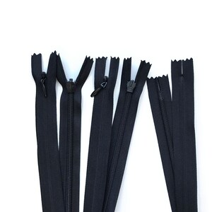 May include: A collection of black zippers of varying lengths, arranged against a white background. Each zipper features a black pull tab and teeth. The zippers are designed for sewing and garment construction.