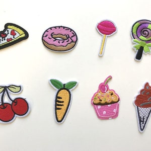 Könnte beinhalten: Satz von zehn gestickten Bügelbildern mit verschiedenen Lebensmittel- und Dessertmotiven, darunter ein Pizzastück, ein Donut, ein Lollipop, ein Cupcake, eine Karotte, Kirschen, ein Eis am Stiel und zwei Lollipops.