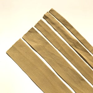May include: Five strips of beige fabric with a herringbone pattern.