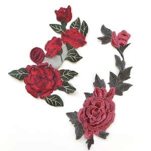 May include: Two embroidered floral appliques with red roses and green leaves. The appliques are perfect for adding a touch of elegance to clothing, bags, or home decor projects.
