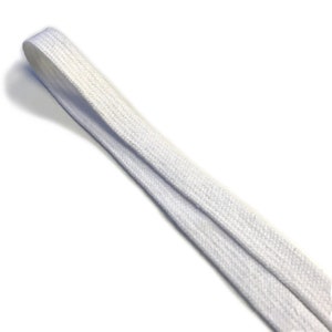 May include: White cotton shoelace, flat and narrow, with a smooth texture.